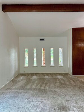 A room with a sloped ceiling, a wooden door, and five windows. - Perfect Transition Home (Plano)
