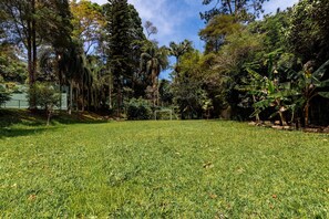 A grassy field with a soccer goal, surrounded by dense trees and a clear sky. - 5BR: Tennis Court, Sauna & Nightclub, 30min SP (Carapicuíba)