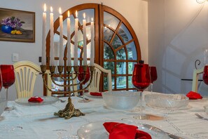 A dining table set for a meal with a candelabra, wine glasses, and a decorative centerpiece. - 5BR: Tennis Court, Sauna & Nightclub, 30min SP (Carapicuíba)
