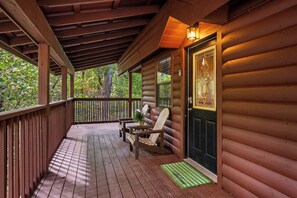 A wooden porch with a bench and a door with a decorative glass panel. - Hot Tub-Fireplace-Private-Honeymoon-Hiking-Relax (Sevierville)