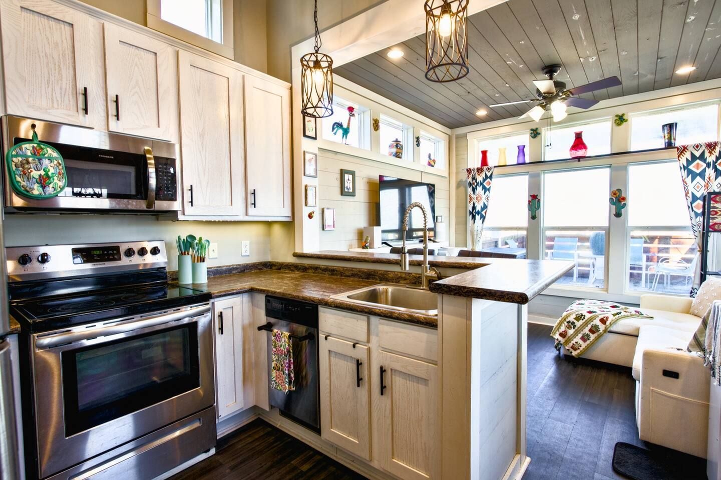 A kitchen with built-in appliances, a central island, and a view to an outdoor patio area.