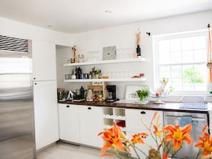A modern kitchen with white cabinetry, a stainless steel refrigerator, and a window providing natural light. - Pet-Friendly Farmhouse | Weddings, Special Events, Corporate Retreats + More! (Belleville)