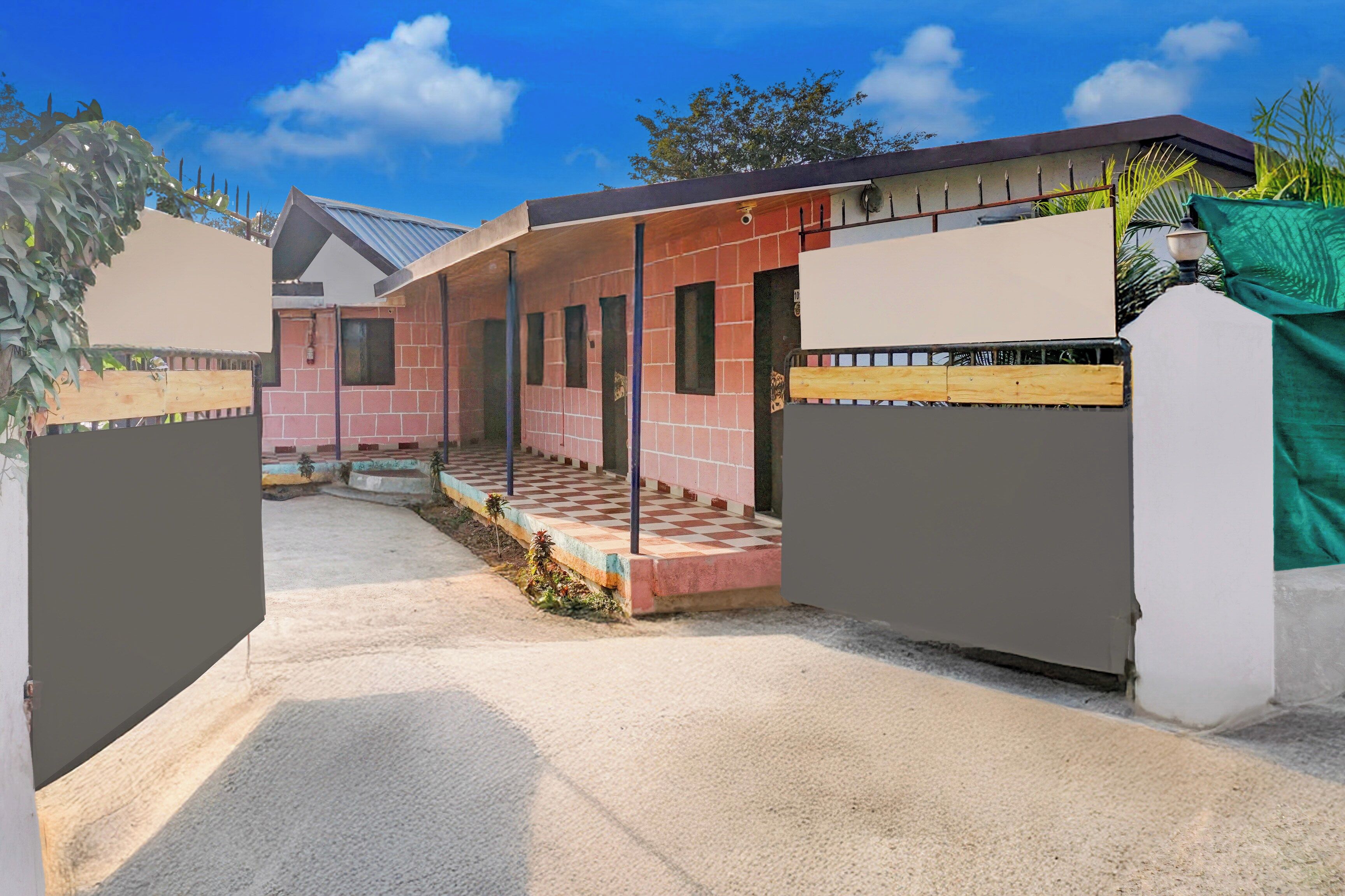 Propiedad residencial con un patio cubierto, fachada de ladrillo y entrada protegida por un portón.