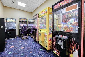 Eine Reihe von Spielautomaten in einem Raum mit gemustertem Teppich und Fliesen Decke.