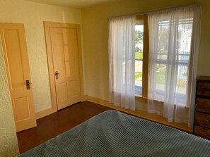 A room with a bed, two doors, and a window with sheer curtains. - Pet friendly 3-bedroom house in Clarendon next to Allegheny national forest (Clarendon)
