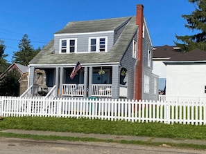 A two-story house with a white picket fence, a front porch, and a chimney. - Pet friendly 3-bedroom house in Clarendon next to Allegheny national forest (Clarendon)