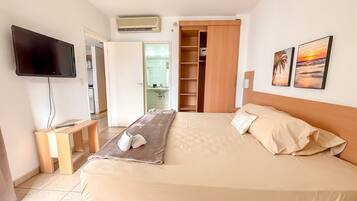 A hotel room with a bed, a TV, a desk, and a wardrobe.