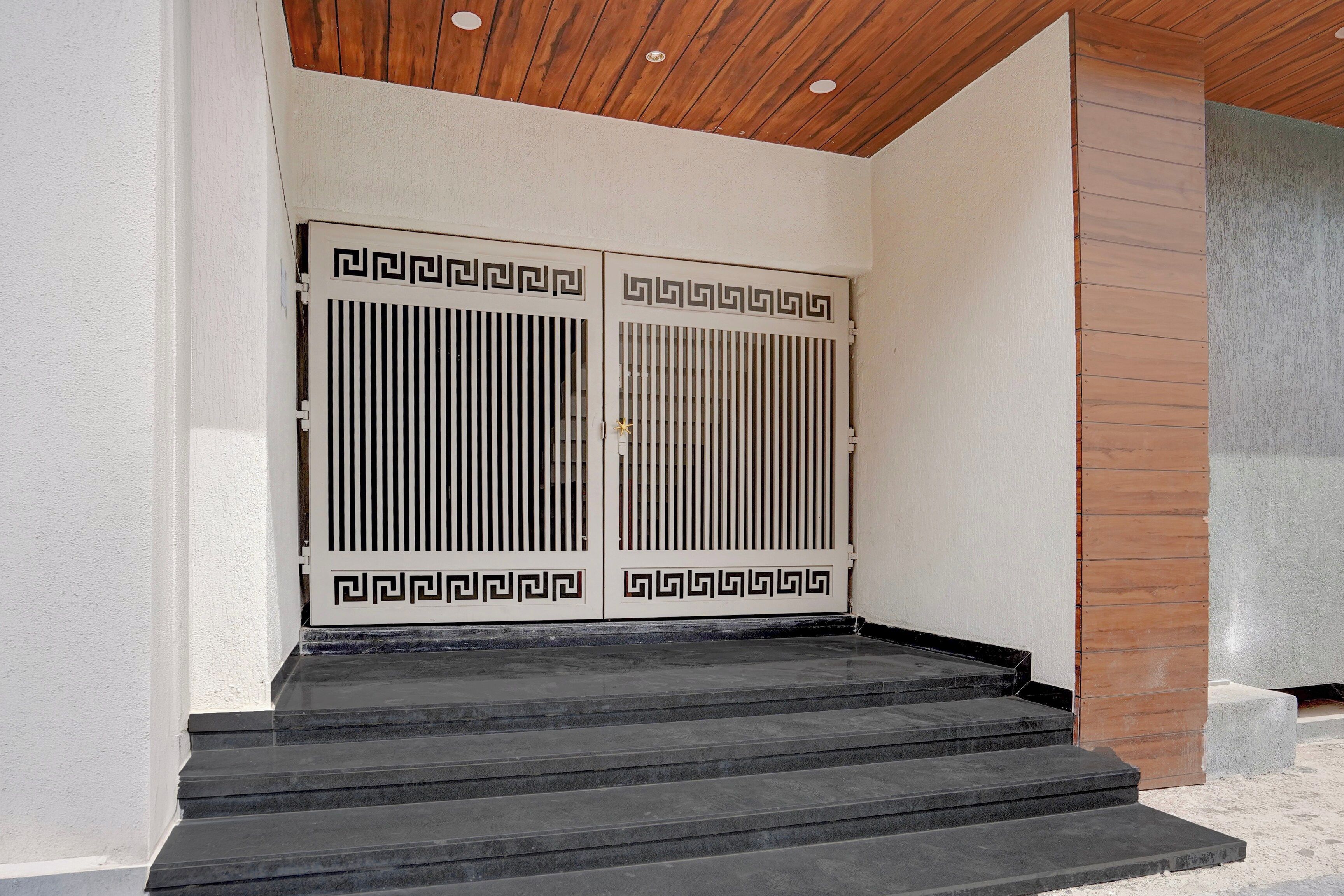 A set of double doors with a geometric pattern, leading to a set of stone steps.