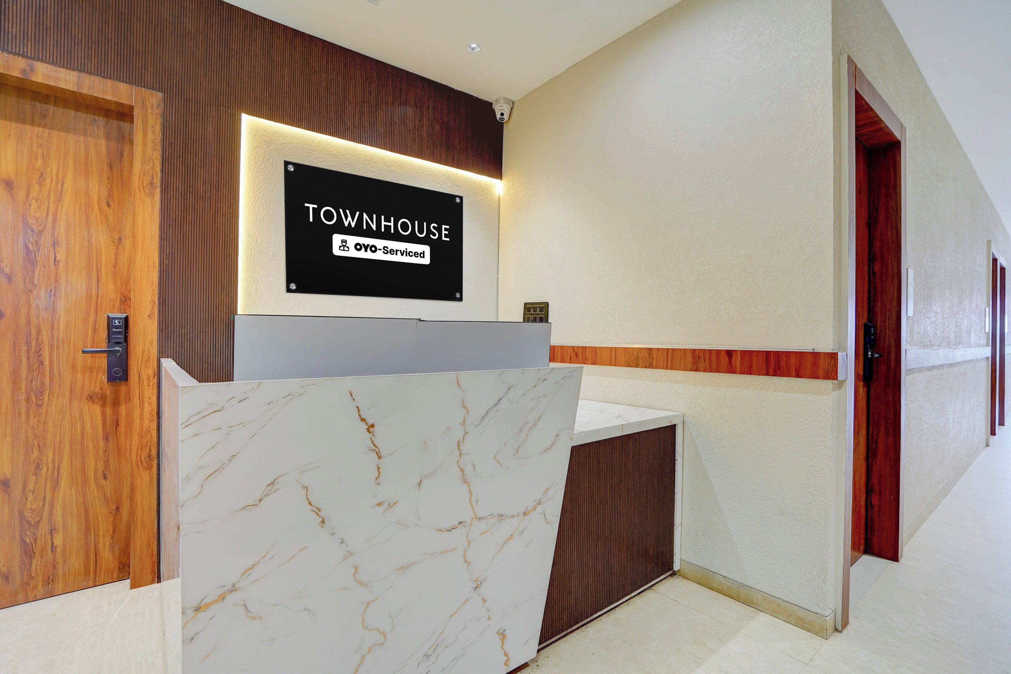 Un mostrador de recepción con un letrero que dice 'TOWNHOUSE OYO-Serviced'.