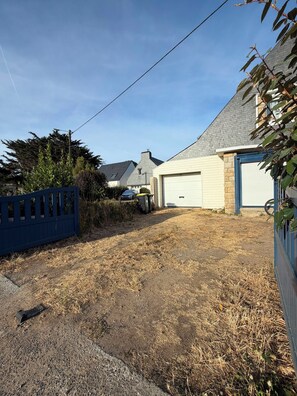 A residential property with a paved driveway, a garage, and a fenced yard. - L’Oasis – Family home for 12, enclosed garden, walk to beach (Saint-Pierre-Quiberon)