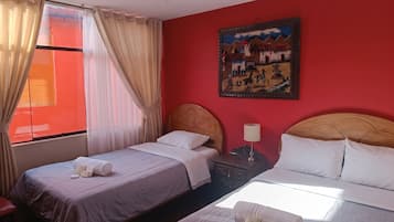 Habitación de hotel con dos camas, un cuadro en la pared y una ventana con cortinas.