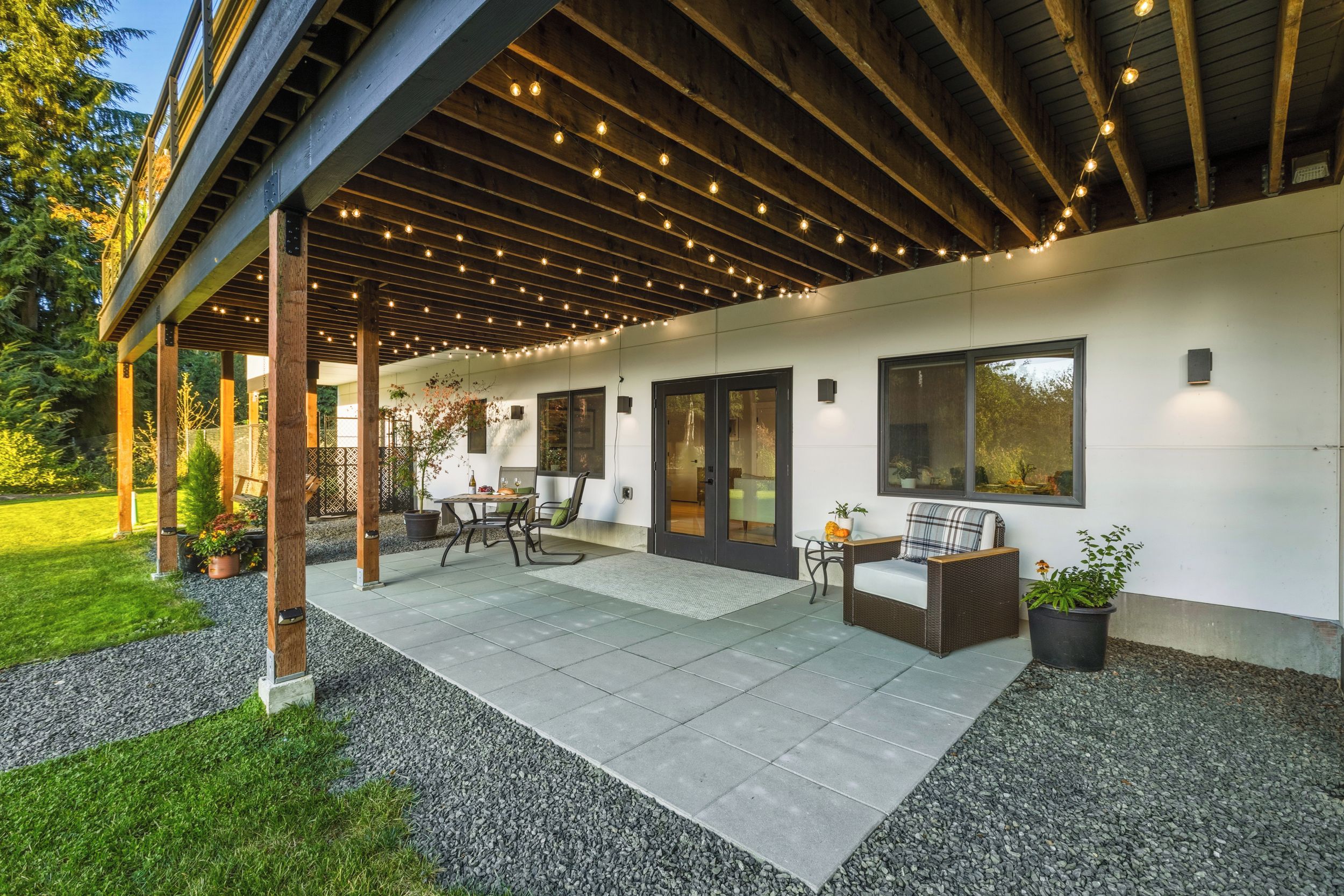 Un espace extérieur aménagé en terrasse, avec un coin salon abrité, une table et des chaises.