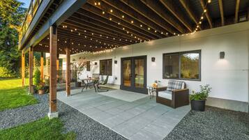 Un espace extérieur aménagé en terrasse, avec un coin salon abrité, une table et des chaises.