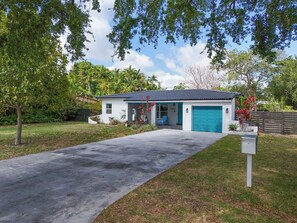 A single-story house with a blue garage door, a concrete driveway, and a mailbox. - Miami Home: Private Yard, Near Beaches & Dining (Miami)
