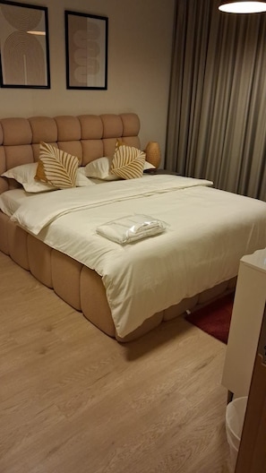 A hotel room with a large bed, a headboard, and a bedside table. - POMMA HOLIDAYS Spacious 1BR Retreat in Dubai JVC Sleeps 4 with Modern Amenities (Dubai)
