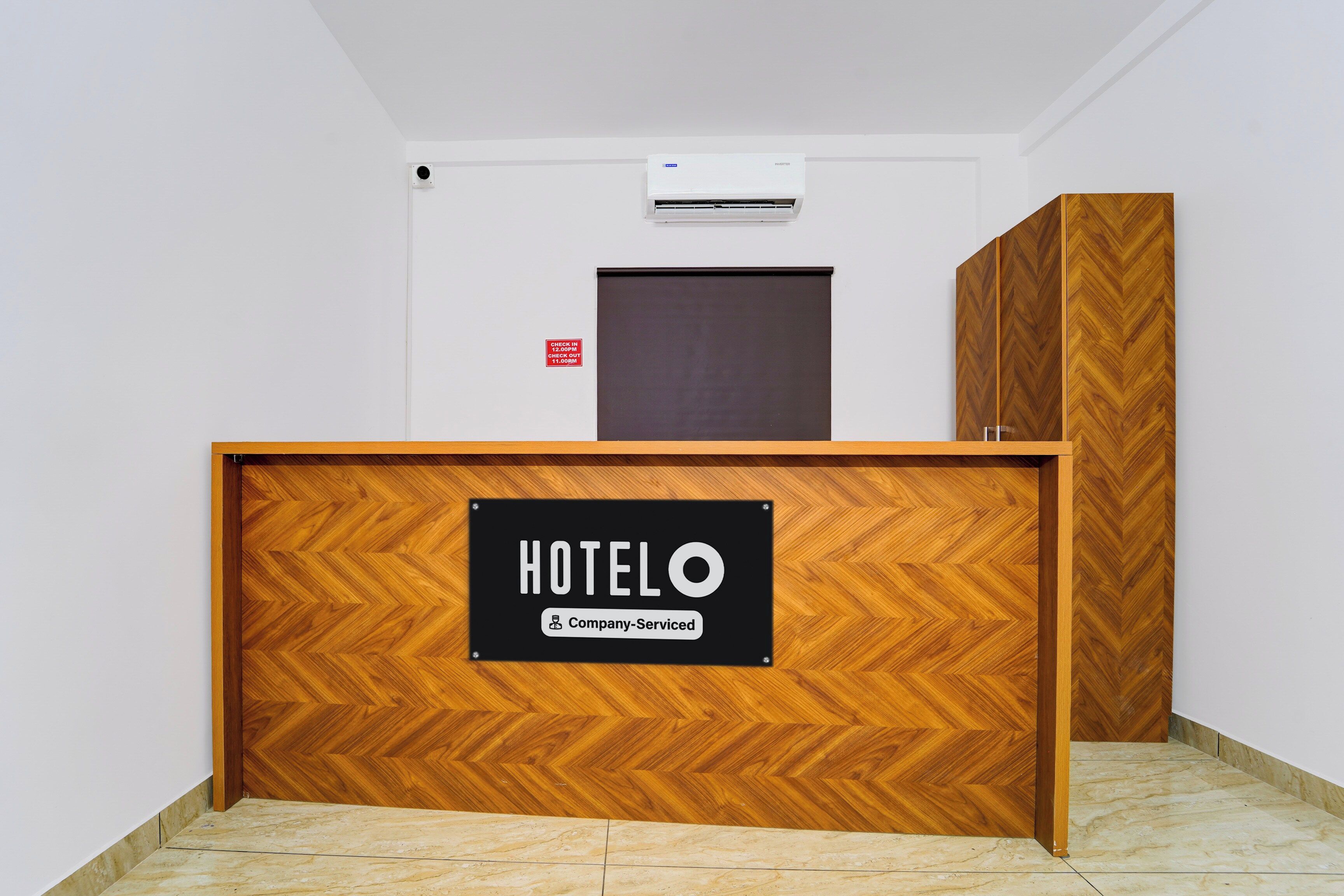 A hotel reception desk with a sign indicating it is company-serviced.
