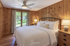 A bedroom with a bed, nightstands, a ceiling fan, and a view of the outdoors. - 5 bed 2 bath cottage on Prime location on Lake Joseph (Seguin)