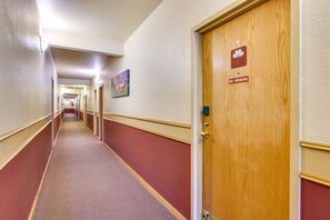 A hotel hallway with a wooden door marked 'NO SMOKING' and a red carpeted floor. - Winter Park Condo w Hot Tubs, Views & Loft! (Winter Park)