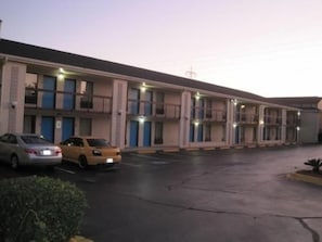 A motel with multiple rooms, a parking lot, and a few cars parked. - Bestway Inn (Rock Hill)