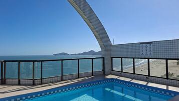 Una piscina con vistas al océano y a la playa.
