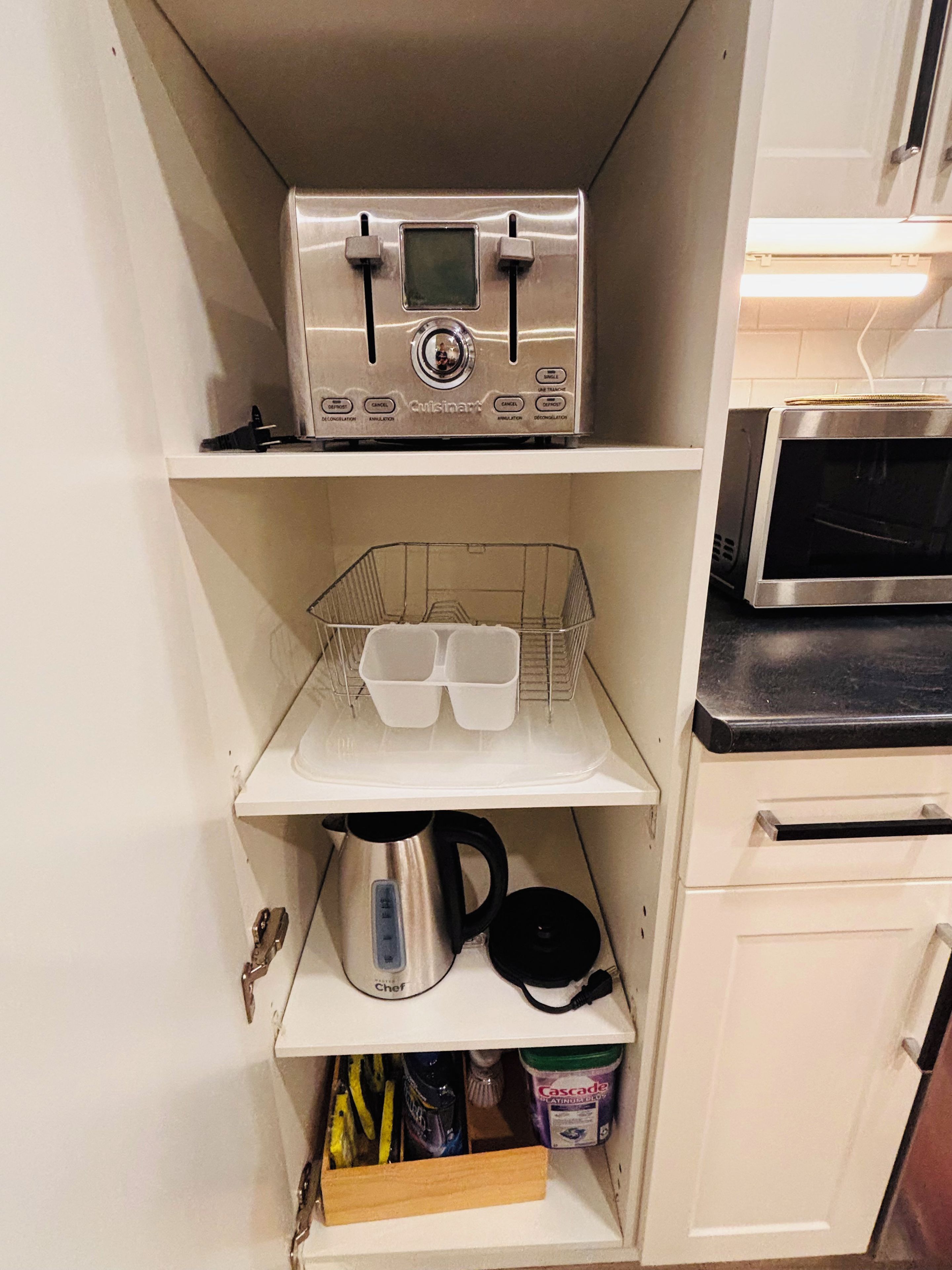 Eine Küche mit integriertem Mikrowellenherd, einer Kaffeemaschine und einem Toaster.