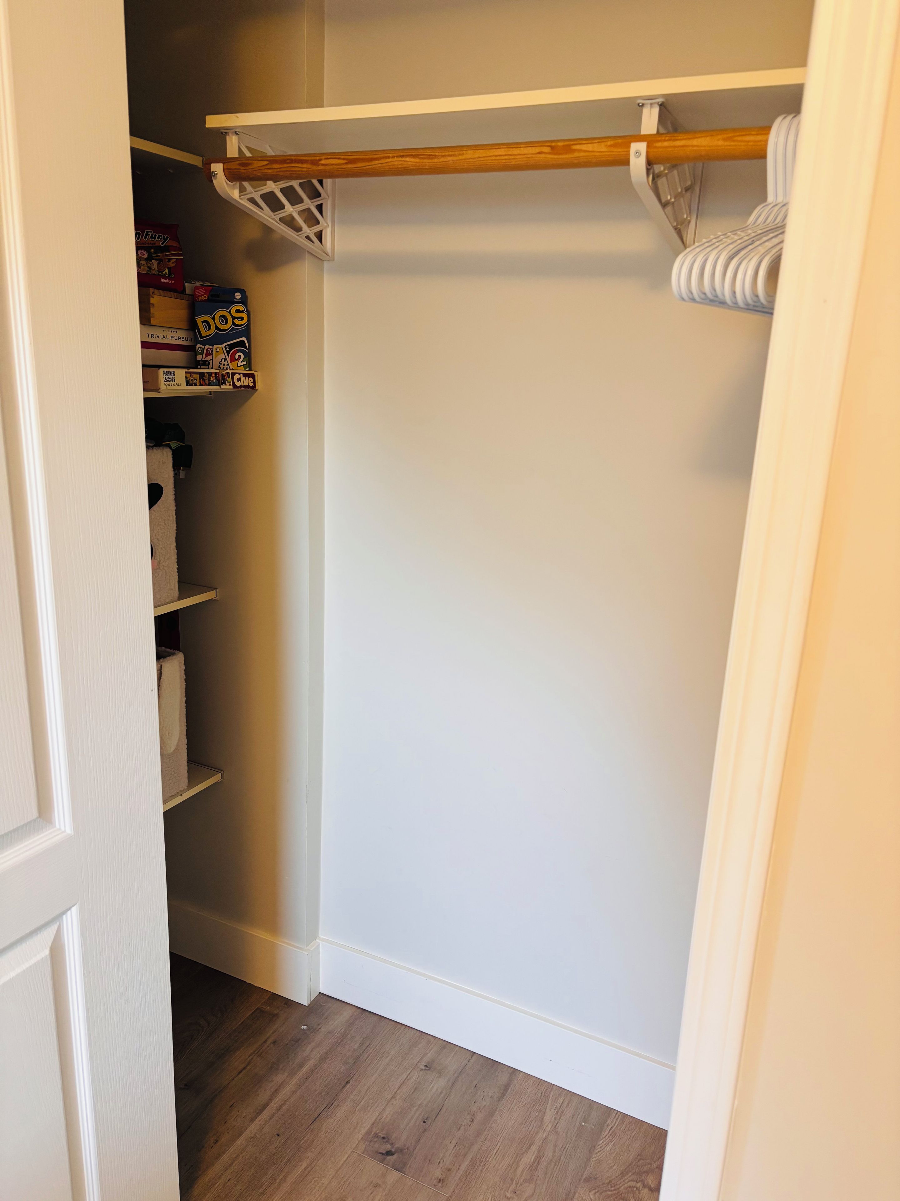 A closet with shelves and a wooden rod for hanging items.