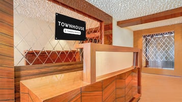 Un mostrador de recepción con un cartel que indica los servicios 'Townhouse' y 'Company-Serviced'.