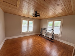 A room with wooden flooring, a ceiling fan, and two windows with blinds. - Cowboy Casita~Walk to 11th St. Cowboy Bar (Bandera)