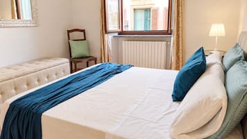 Een hotelkamer met een bed, een stoel, een lamp en een raam.