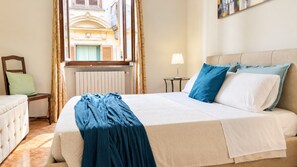 A hotel room with a bed, a chair, a table, and a window with curtains. - QuickHome Via Italia 43 (Biella)