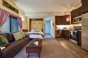 A hotel room with a bed, a sofa, a coffee table, and a kitchenette. - Updated North Tahoe Studio | Pool, Spa & Pines (Tahoe Vista)