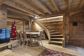 Un interno in legno con zona pranzo, televisore e albero di Natale.