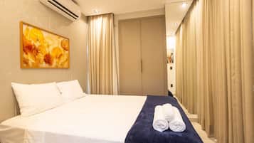 Una habitación de hotel con una cama, un cuadro y un juego de cortinas.