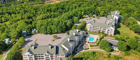 A large resort with multiple buildings, a swimming pool, and extensive greenery.