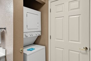 Stacked washer and dryer in a closet beside a white paneled door. - Cozy Pigeon Forge Condo w/ Kitchen & Balcony (Pigeon Forge)