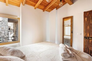 A bedroom with a bed, a window, a mirror, and a door. - Authentic apartment in medieval Apricale (Apricale)