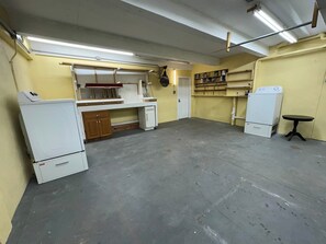 Ein geräumiges Zimmer mit Küchenzeile, einem kleinen Tisch und einem Kühlschrank.