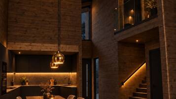 Ein modernes Interieur mit Essbereich, Küche und Treppe.