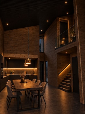 A modern interior with a dining area, kitchen, and staircase. - Ruka Timber Chalets  (Kuusamo)