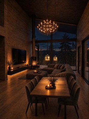 A modern interior with a wooden floor, a large dining table, and a cozy seating area. - Ruka Timber Chalets  (Kuusamo)