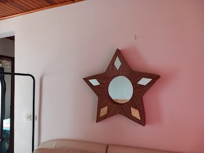 A star-shaped wall decoration with a circular center on a pink wall. - New Listing (VAUCLIN)