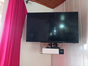A flat-screen TV mounted on a wall with a cable management box below it. - New Listing (VAUCLIN)