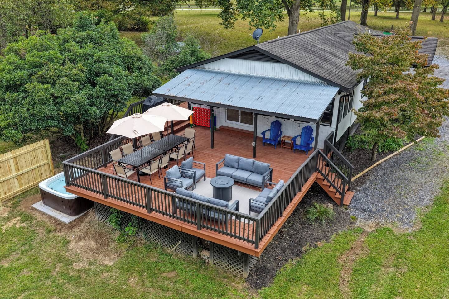 A deck with outdoor furniture, a hot tub, and a covered patio area.