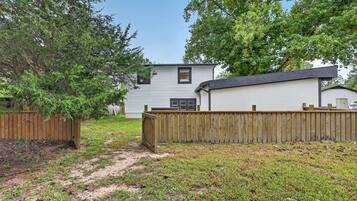 A residential property with a fenced yard, a detached garage, and a house with a gabled roof.