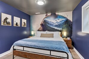 A bedroom with a bed, a nightstand, a wall clock, and three framed pictures. - Riverfront Cabin - Pickleball, Hot Tub, Game Room (Shenandoah)