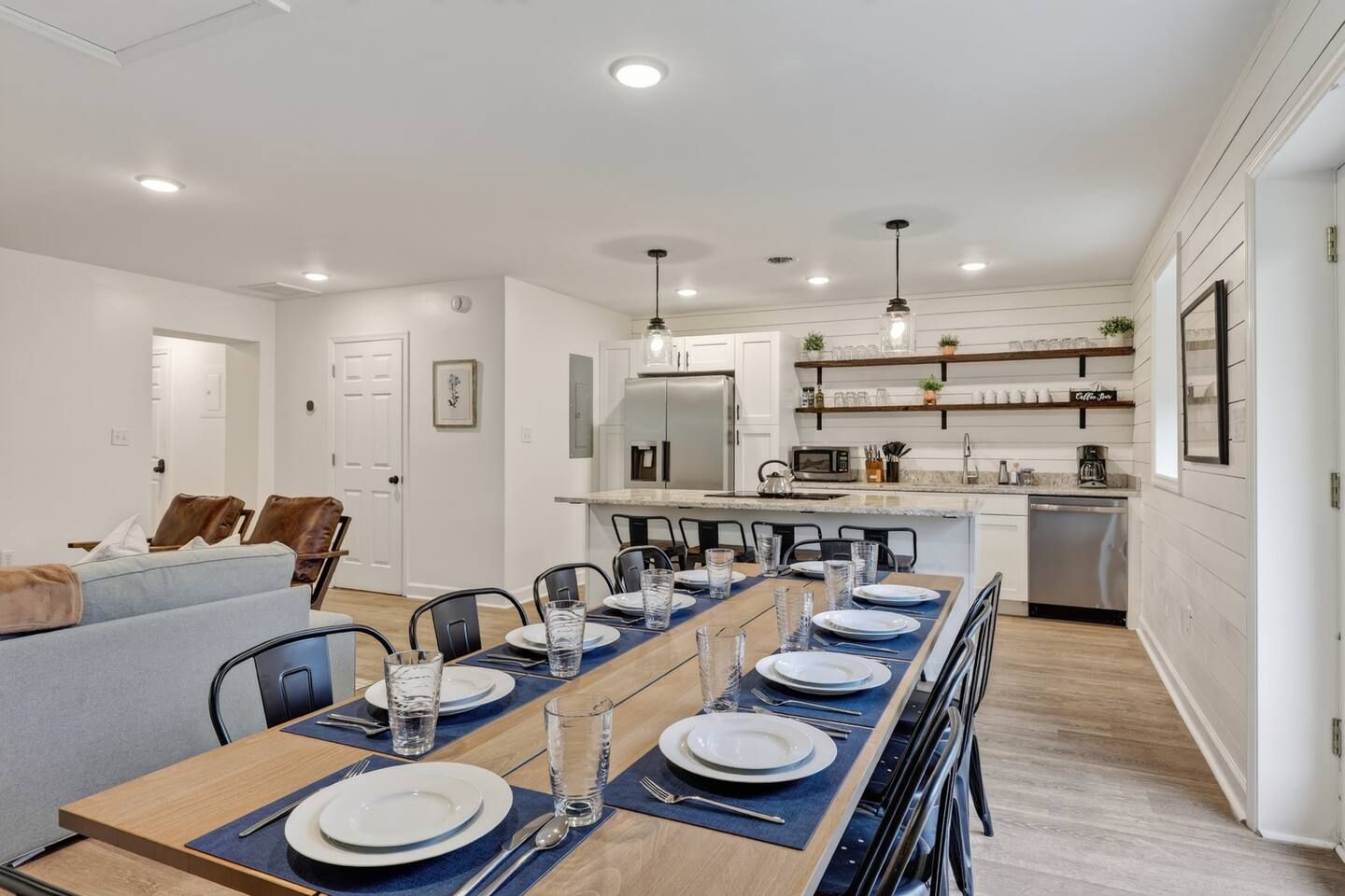 A modern kitchen with white cabinets, a built-in microwave, and a coffee machine.