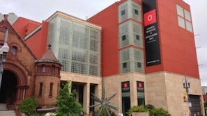 Un edificio con fachada roja, estructura de vidrio y un cartel para el Museo Golden de Arte del Sur.