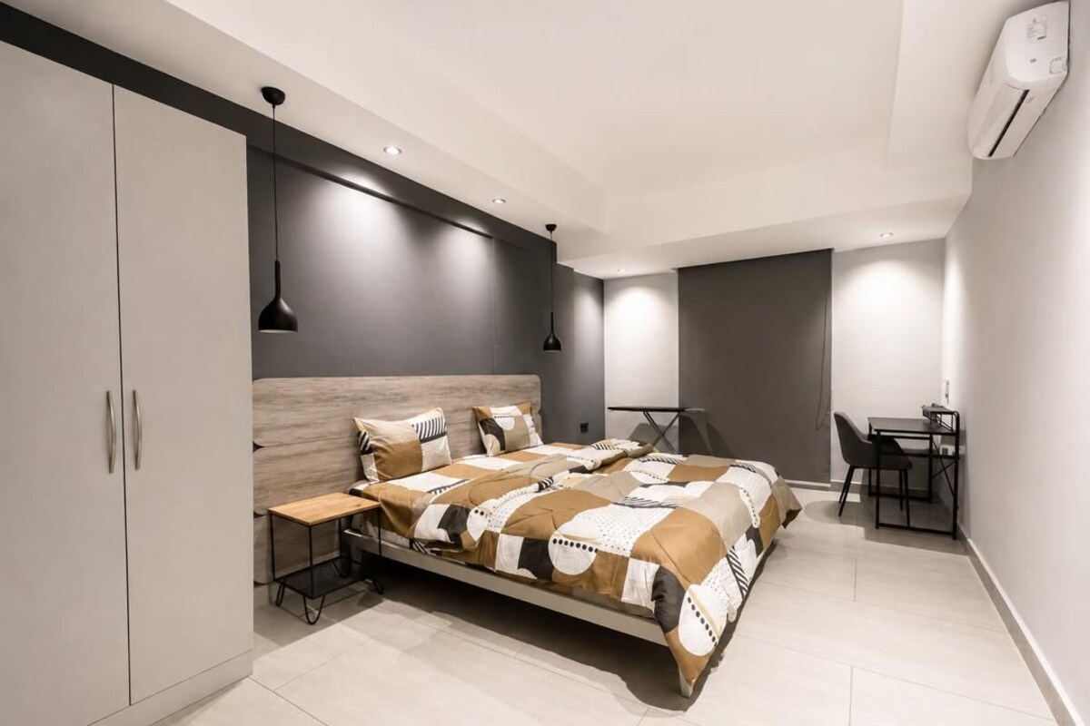 Une chambre moderne avec un lit, une table de chevet et un bureau avec des chaises.