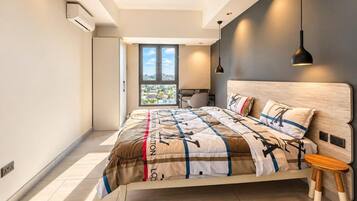Un dormitorio moderno con una cama grande, vistas a la ciudad y una mesita.