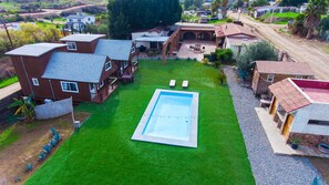 Un quartier résidentiel doté d’une piscine, de plusieurs maisons et d’une pelouse bien entretenue.